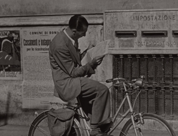 Man Reading Newspaper on Bicycle